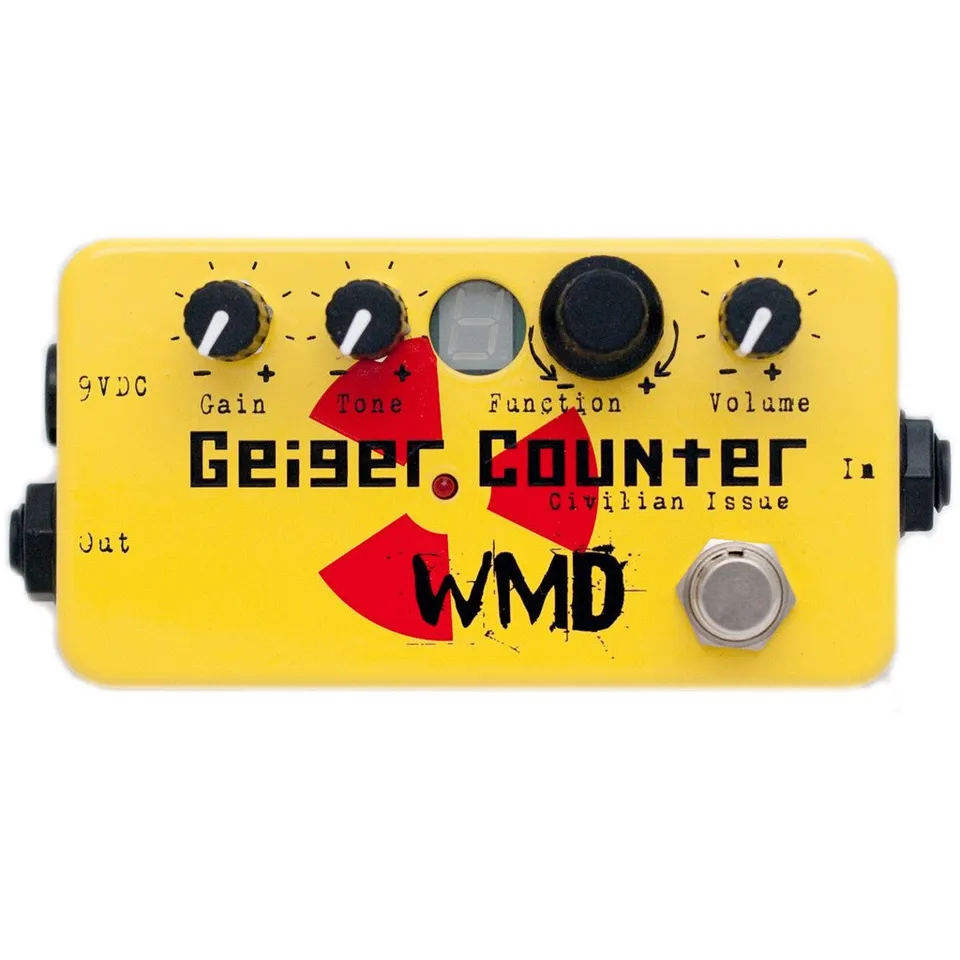 Geiger Counter Civilian Issue pedal, front view: a yellow enclosure with Gain and Tone knobs, a single-digit display, a large Function knob with curved arrows marked minus and plus, and a Volume knob along the top; the Geiger Counter name with Civilian Issue beneath it over a red radiation-hazard symbol with a red LED at its center; the WMD logo; a footswitch at lower right; 9VDC and Out jacks on the left side and the In jack on the right side.